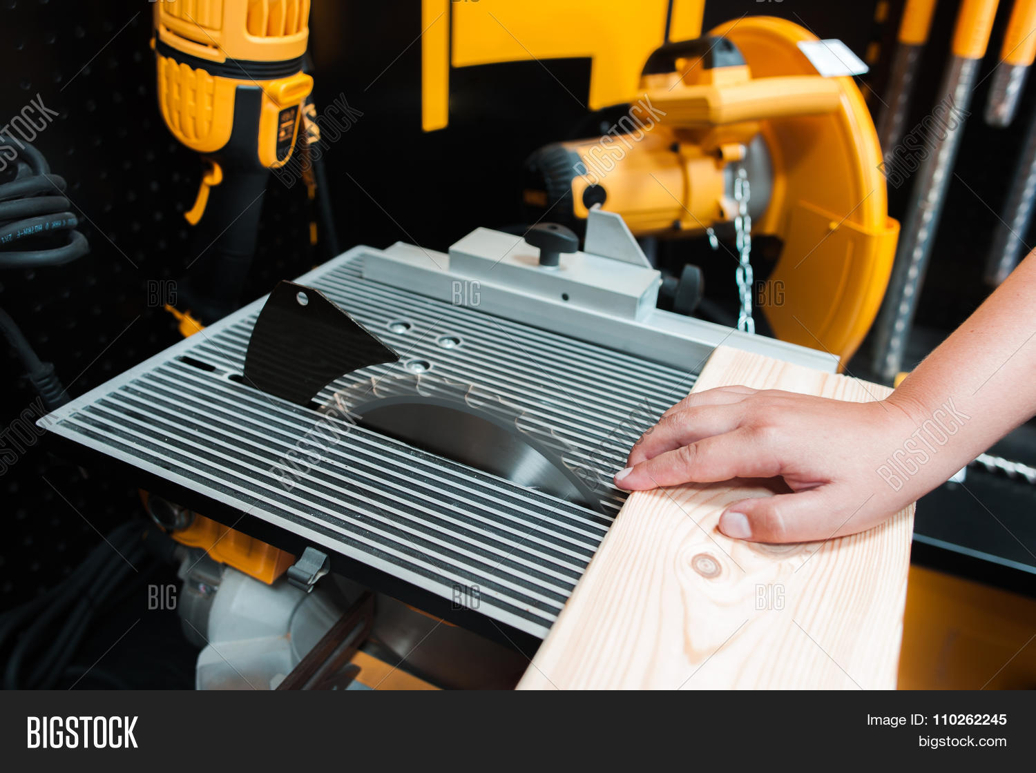 blade,board,carpenter,carpentry,circle,circular,close-up,craft,crafting,craftsman,cut,danger,dangerous,electric,equipment,hand,imminence,industry,injuries,instrument,lumber,machine,man,manufacturing,menace,metal,motion,people,peril,plank,risk,riskily,rotary,safety,saw,sawing,sharp,steel,table,timber,tool,wood,woodwork,woodworking,work,workbench,worker,workplace,workshop,yellow