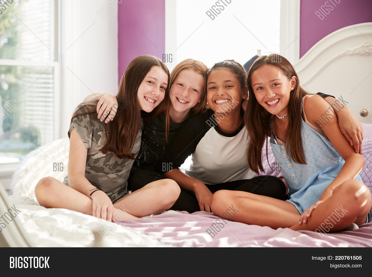 adolescence,arms around,bed,bedroom,bonding,casual clothing,caucasian,children,close up,copy space,dark hair,day,embracing,four people,free time,friends,friendship,front view,full length,fun,girls,girls only,hanging out,happy,hispanic ethnicity,home,horizontal,in a row,indoors,kids,leaning,legs crossed,long hair,looking at camera,multi-ethnic group,pre-teens,red hair,relaxing,sitting,sitting on bed,smiling,socialising,sunlight,teenagers,togetherness,windows,youth