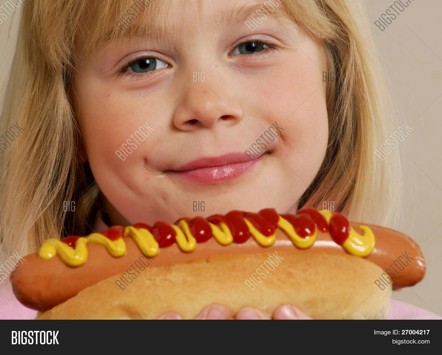Little girl eating a hot dog.Kid eating hot dog. image & stock photo. 27004217 Little girl eating a hot dog.Kid eating hot dog. image & stock photo. 27004217