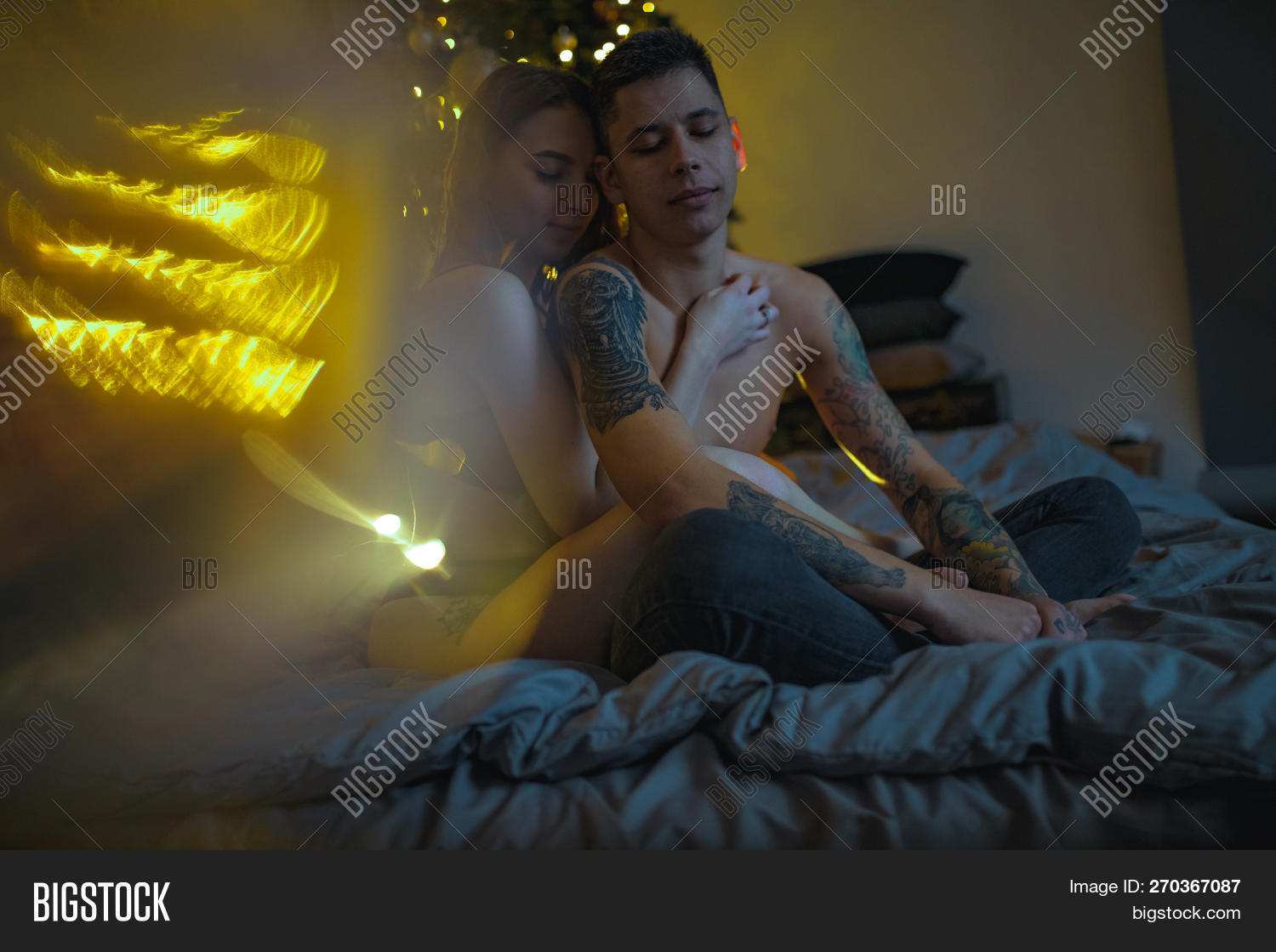 20s,Christmas,adult,affection,attractive,beautiful,bed,bedclothes,bedroom,boyfriend,caucasian,couple,decorations,desire,female,foreplay,girlfriend,happy,home,hugging,indoor,intimacy,intimate,lightbulbs,love,lovemaking,lovers,male,man,passion,passionate,people,person,relationship,romance,romantic,room,sensual,sensuality,sex,sexual,sexy,sitting,tattoo,together,tree,two,unclothed,woman,young