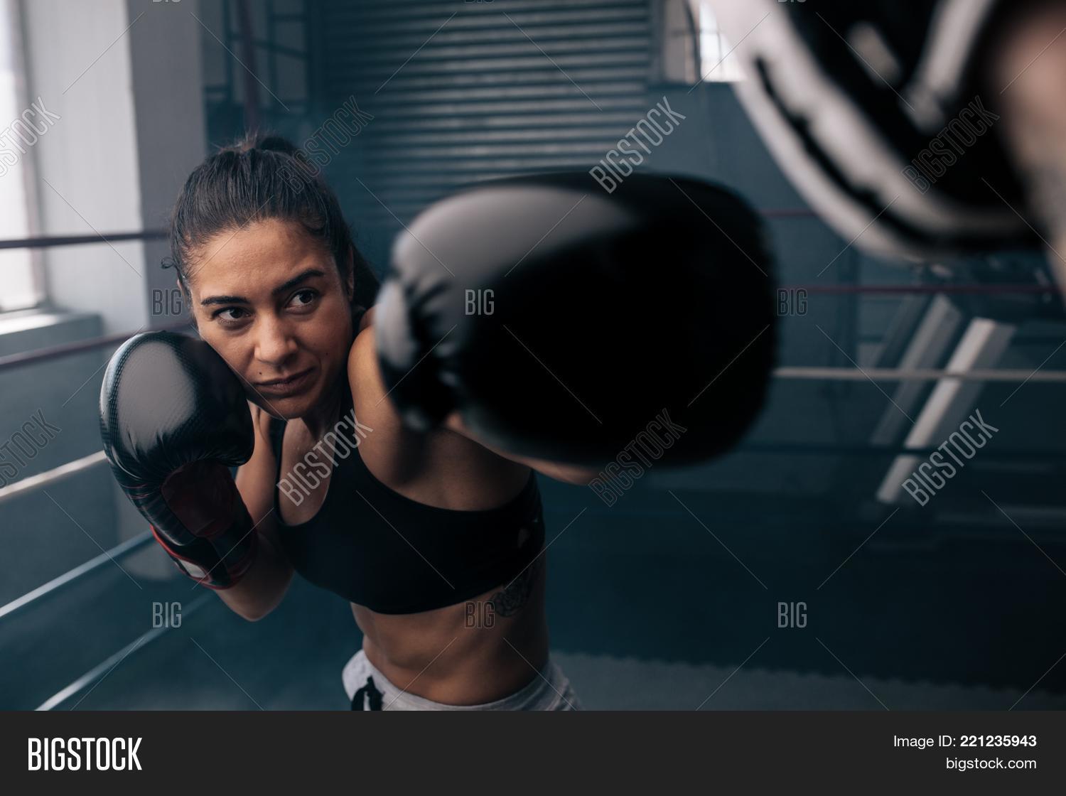 arts,at,athlete,body,boxer,boxing,camera,close,club,exercise,female,fight,fit,fitness,gym,kickboxing,looking,martial,muscular,one,person,portrait,practicing,self-defense,sport,sportswear,strength,sweat,training,up,woman,workout