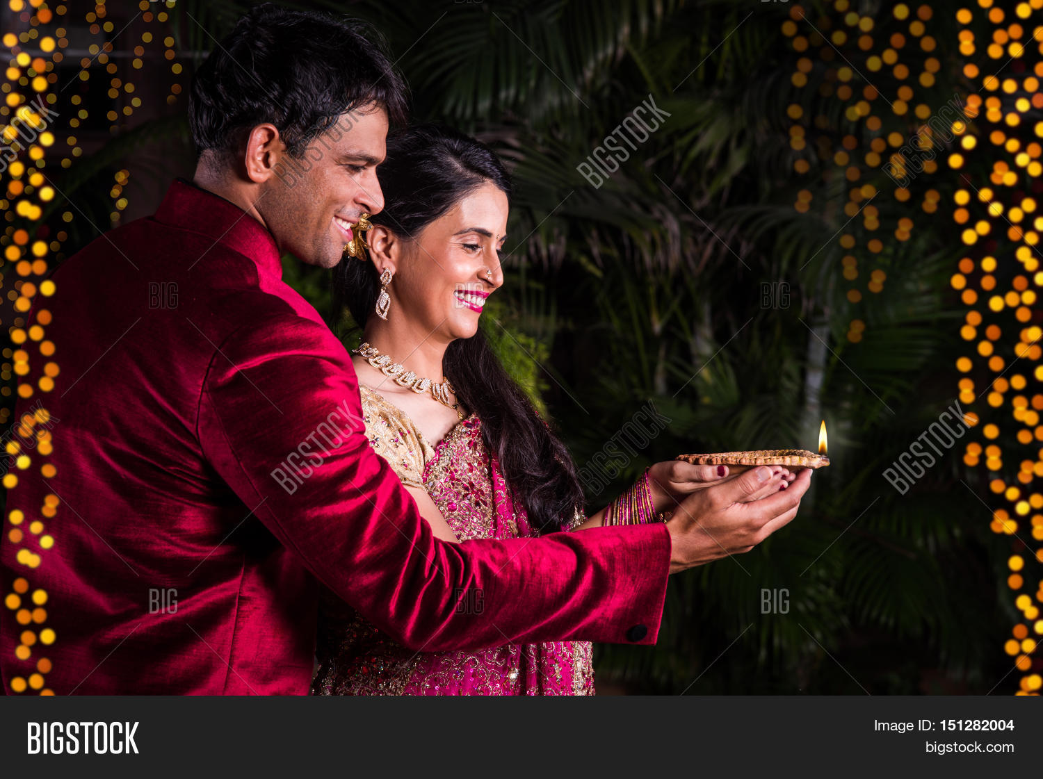 closeup,facial,decoration,saree,2,lamp,expression,bonding,pose,celebrate,wife,festive,celebration,hold,traditional,posing,portrait,dress,smile,women,togetherness,youth,decorate,welcoming,young,contact,indian,standing,tradition,festival,husband,background,couple,pretty,happy,lights,diwali,20-25,deepawali,deepavali,diya,divali,bokeh