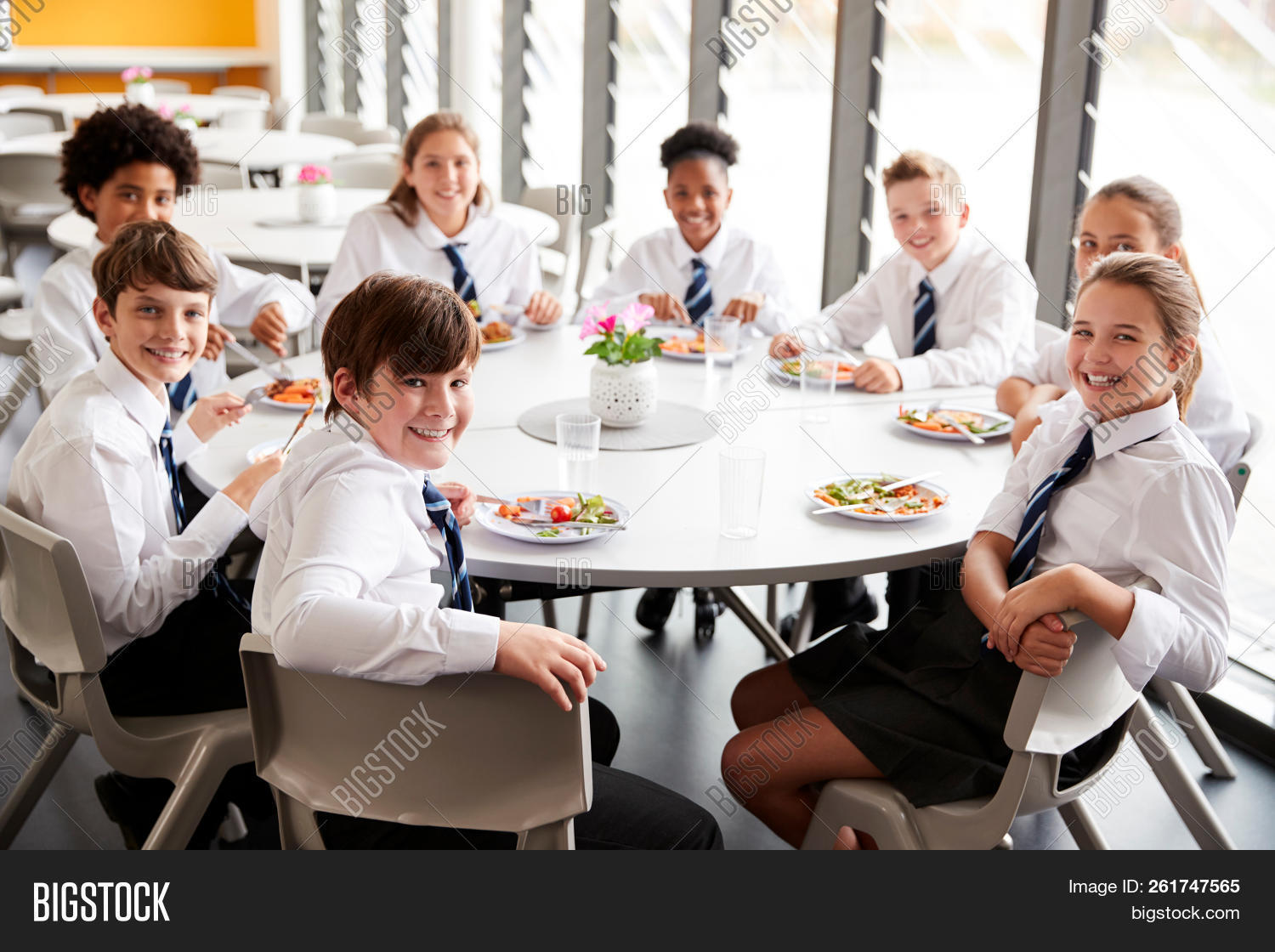 11 years old,12 years old,african american,black,boy,cafeteria,canteen,caucasian,eating,education,enjoyment,female,food,friends,front view,girl,happy,healthy,high school,horizontal,independent school,looking at camera,lunch,male,meal,mixed race,nutrition,people,person,portrait,private school,public school,pupil,sitting,smiling,student,table,together,uk,uniform