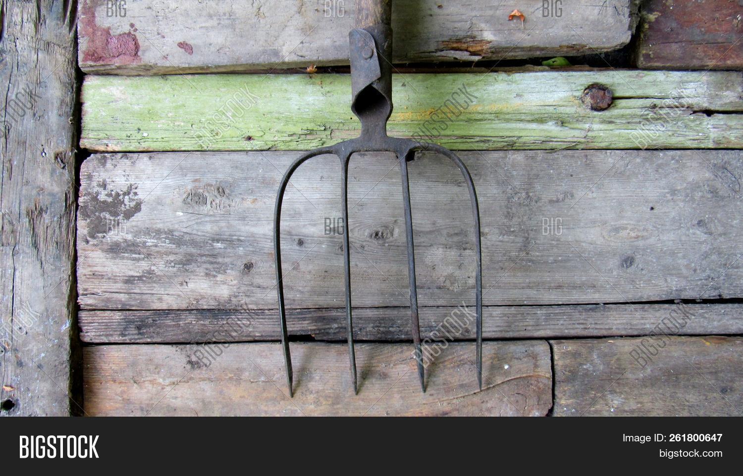 agriculture,background,brown,closeup,dark,design,detail,dirty,equipment,farm,farming,fork,garden,gardening,handle,material,metal,natural,nature,object,old,pattern,pitchfork,plant,rake,retro,rustic,surface,texture,textured,tool,vintage,wall,wood,wooden,work