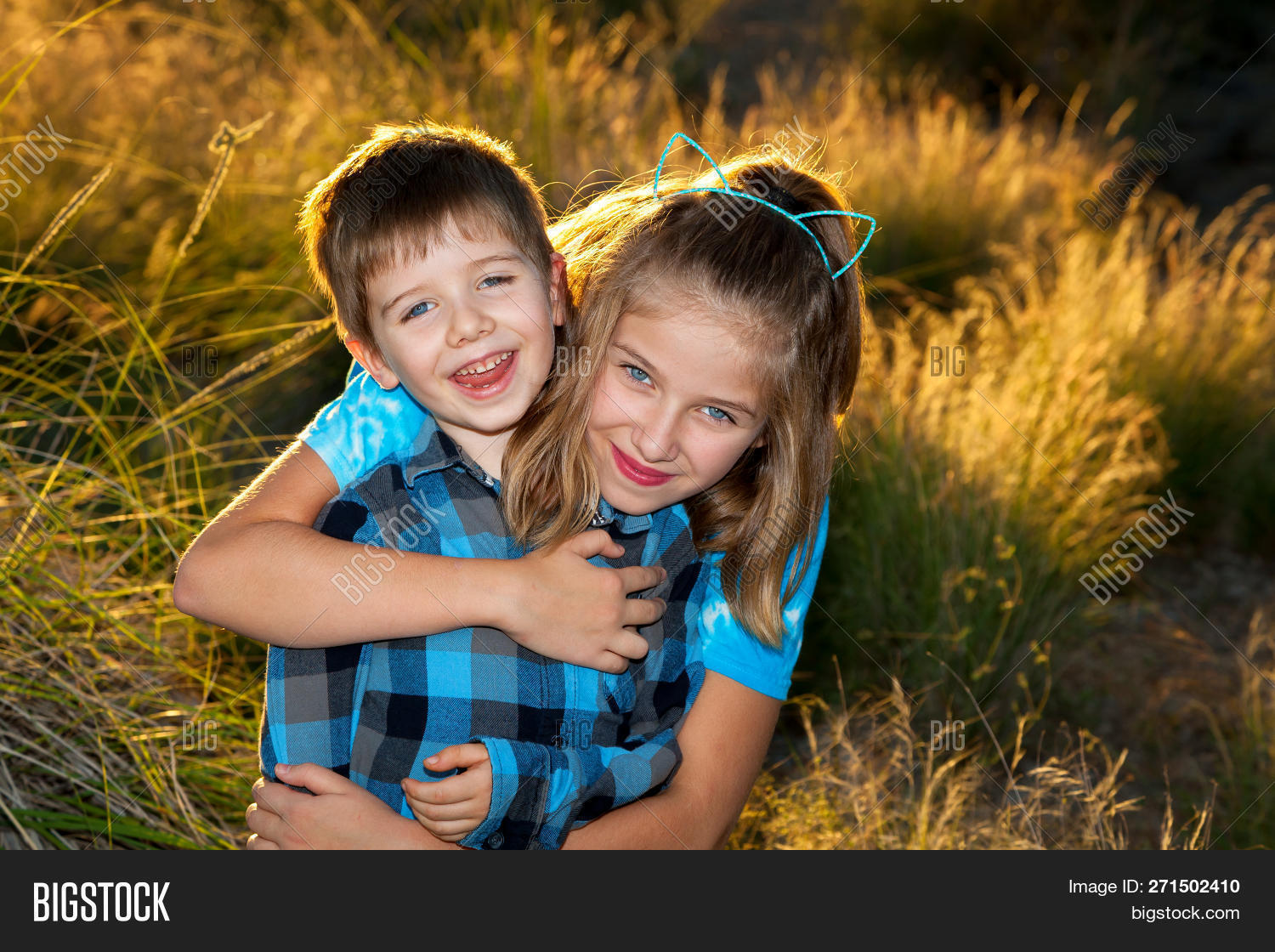 afternoon,backlit,blond,blue,boy,brother,cat,caucasian,cheerful,child,childhood,copy,ears,expression,eyelid,eyes,family,female,fun,girl,golden,happiness,happy,hour,hug,joy,joyful,kid,late,little,love,male,nature,outdoors,outside,park,people,person,playful,portrait,posing,ptosis,siblings,sister,smile,space,together,two,young,youth