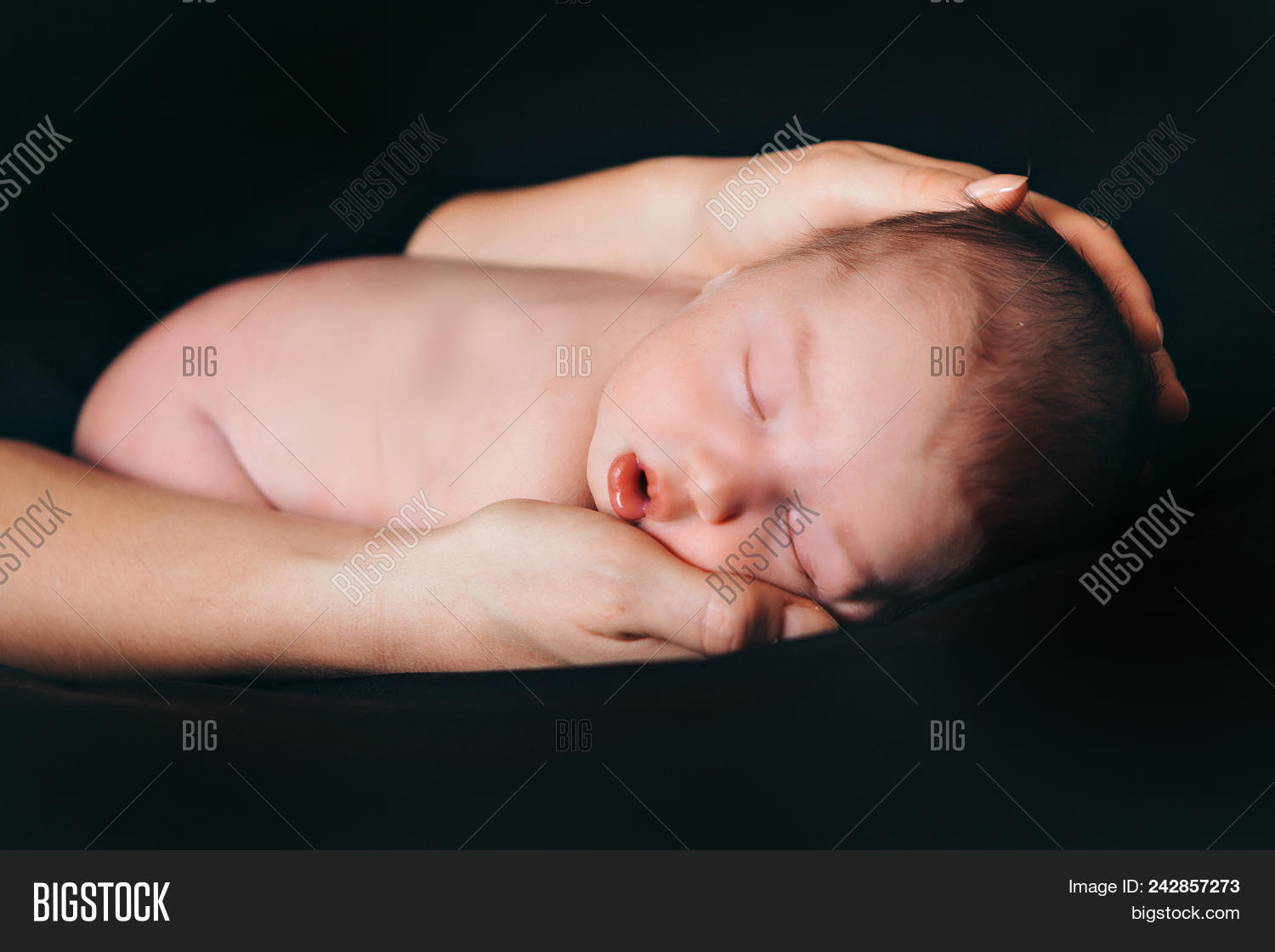 Newborn Baby Lying On The Hands Of Parents On A Black Background Imitation Of A Baby In The Womb Image Stock Photo