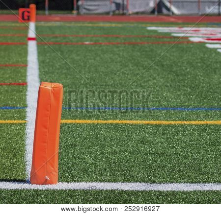 The End Zone Of A Football Field Is Marked With Orange Pylons. image