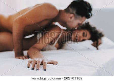 Young Beautiful Couple In Underwear Lying On Bed. Handsome Man Kissing Attractive Woman. Passionate