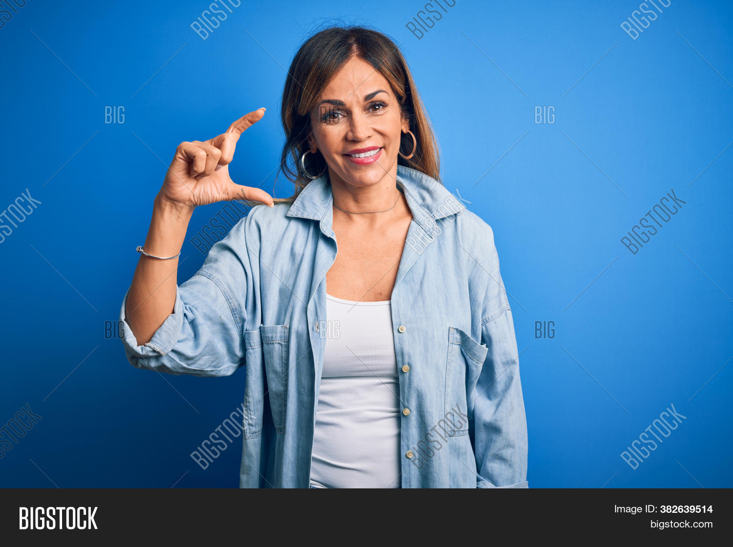 arm, 																					attractive, 																					background, 																					beautiful, 																					big, 																					blue, 																					brunette, 																					casual, 																					cheerful, 																					concept, 																					confident, 																					cool, 																					fashion, 																					female, 																					finger, 																					fingers, 																					gesture, 																					gesturing, 																					hand, 																					hands, 																					happy, 																					hispanic, 																					isolated, 																					large, 																					little, 																					mature, 																					measure, 																					measuring, 																					middle age, 																					model, 																					palm, 																					people, 																					person, 																					pinch, 																					portrait, 																					scale, 																					shirt, 																					show, 																					showing, 																					sign, 																					size, 																					small, 																					smile, 																					smiling, 																					standing, 																					studio, 																					symbol, 																					thumb, 																					wall, 																					woman