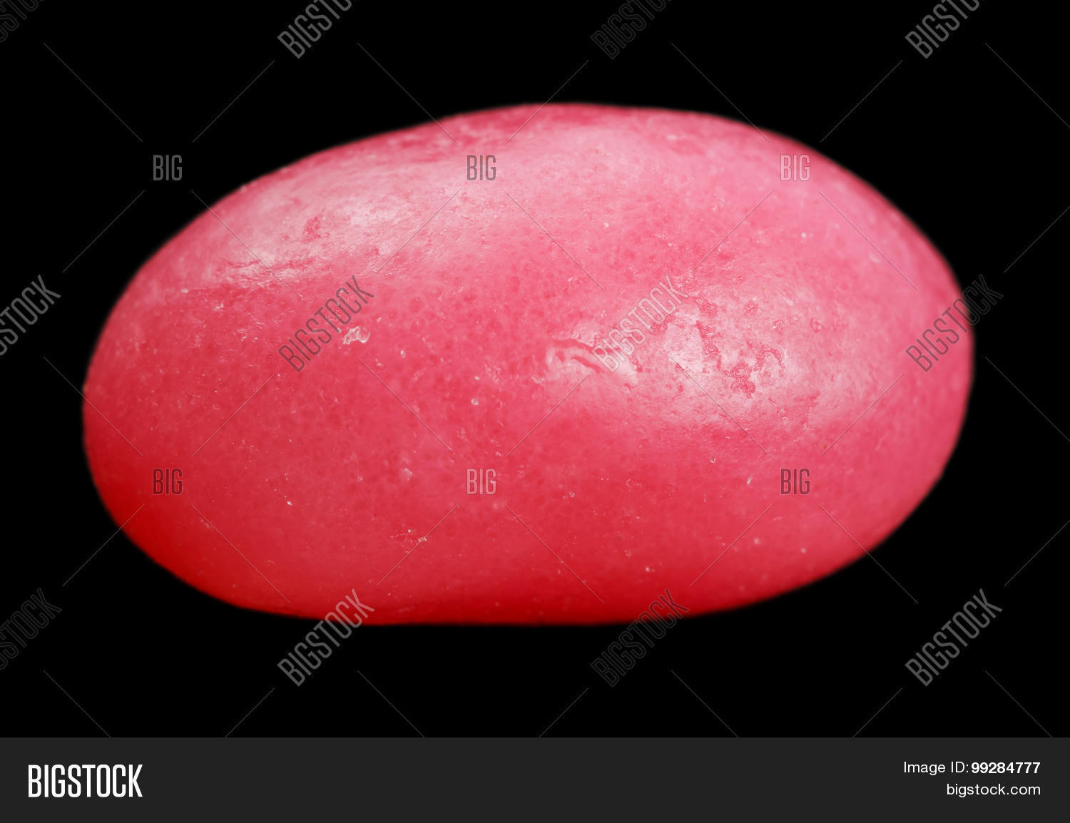 ✓ One pink jelly bean isolated on black background image ...
