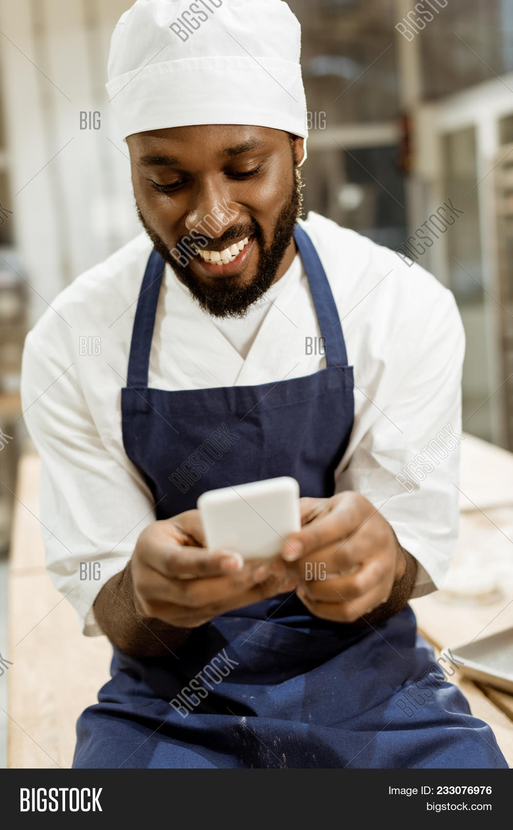 african,american,apron,bake,bakehouse,baker,bakery,black,chef,computer,cook,device,digital,electronics,factory,flour,food,gadget,happy,hat,industrial,industry,job,male,man,manufacture,manufacturing,network,networking,occupation,pastry,people,person,phone,production,profession,professional,smartphone,smile,smiling,uniform,worker,working,workplace