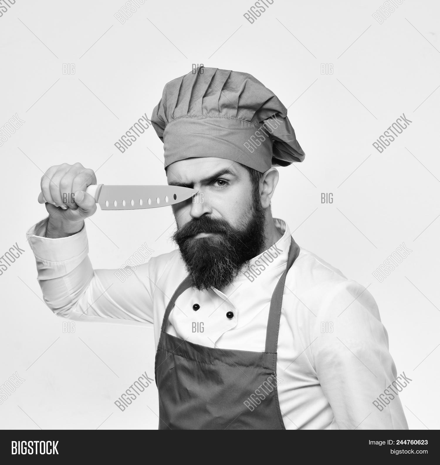 adult,apron,background,beard,bearded,blade,blue,burgundy,butch,butcher,cafe,caucasian,chef,chopper,concept,cook,cooking,cuisine,culinary,cut,equipment,eye,face,gourmet,hat,hold,isolated,job,kitchen,knife,male,man,metal,mustache,occupation,profession,professional,restaurant,serious,sharp,staff,steel,tool,uniform,utensil,white,work,young