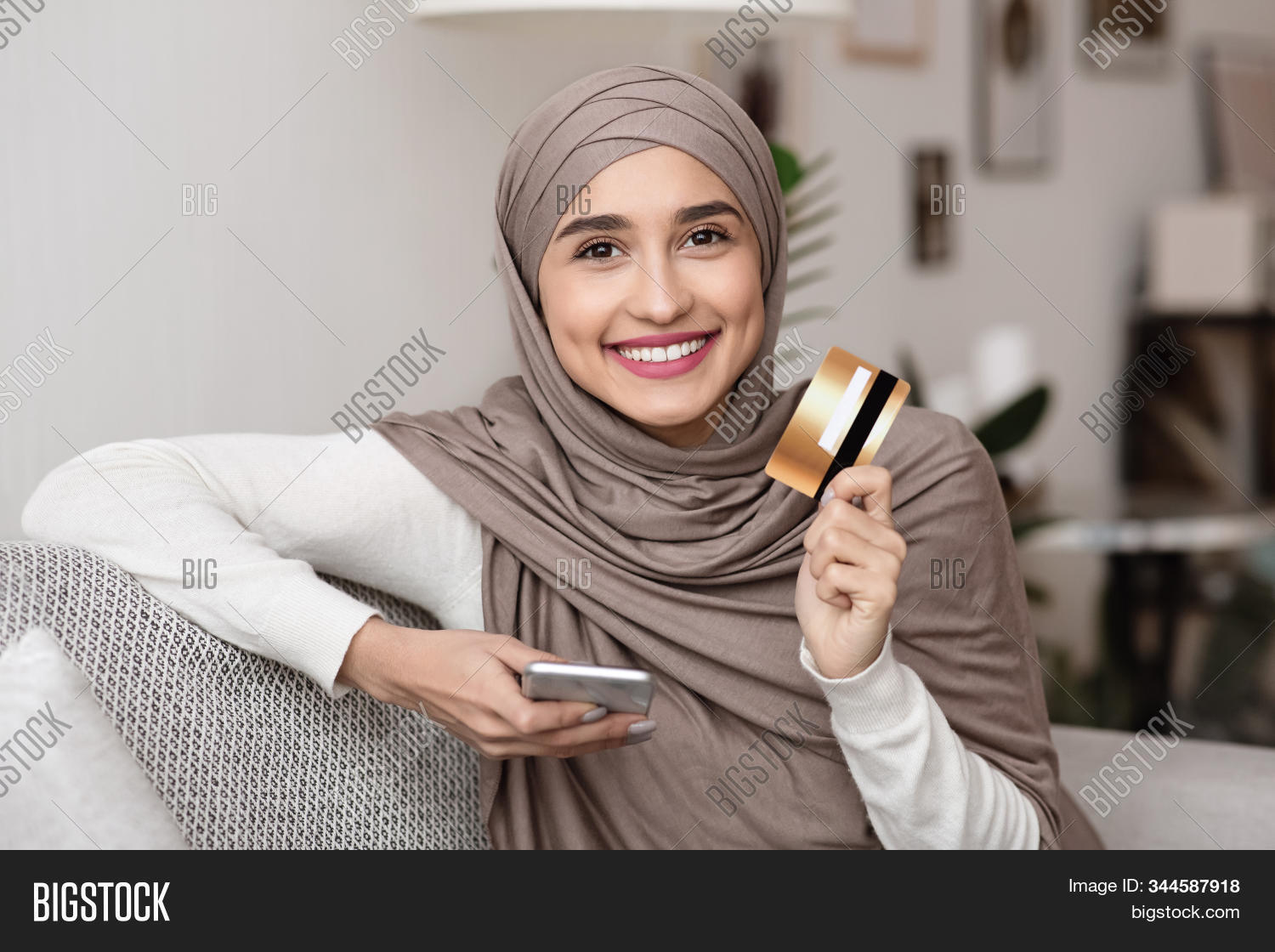 smartphone,female,arabian,money,phone,woman,adult,technology,headscarf,electronic,sitting,home,shopping,website,muslim,lifestyle,couch,network,gadget,hands,app,girl,islamic,device,hijab,internet,buy,card,ethnicity,purchase,modern,business,success,banking,young,arabic,happy,millennial,indoors,beautiful,application,wallet,smiling,online,people,payment,e-commerce,credit