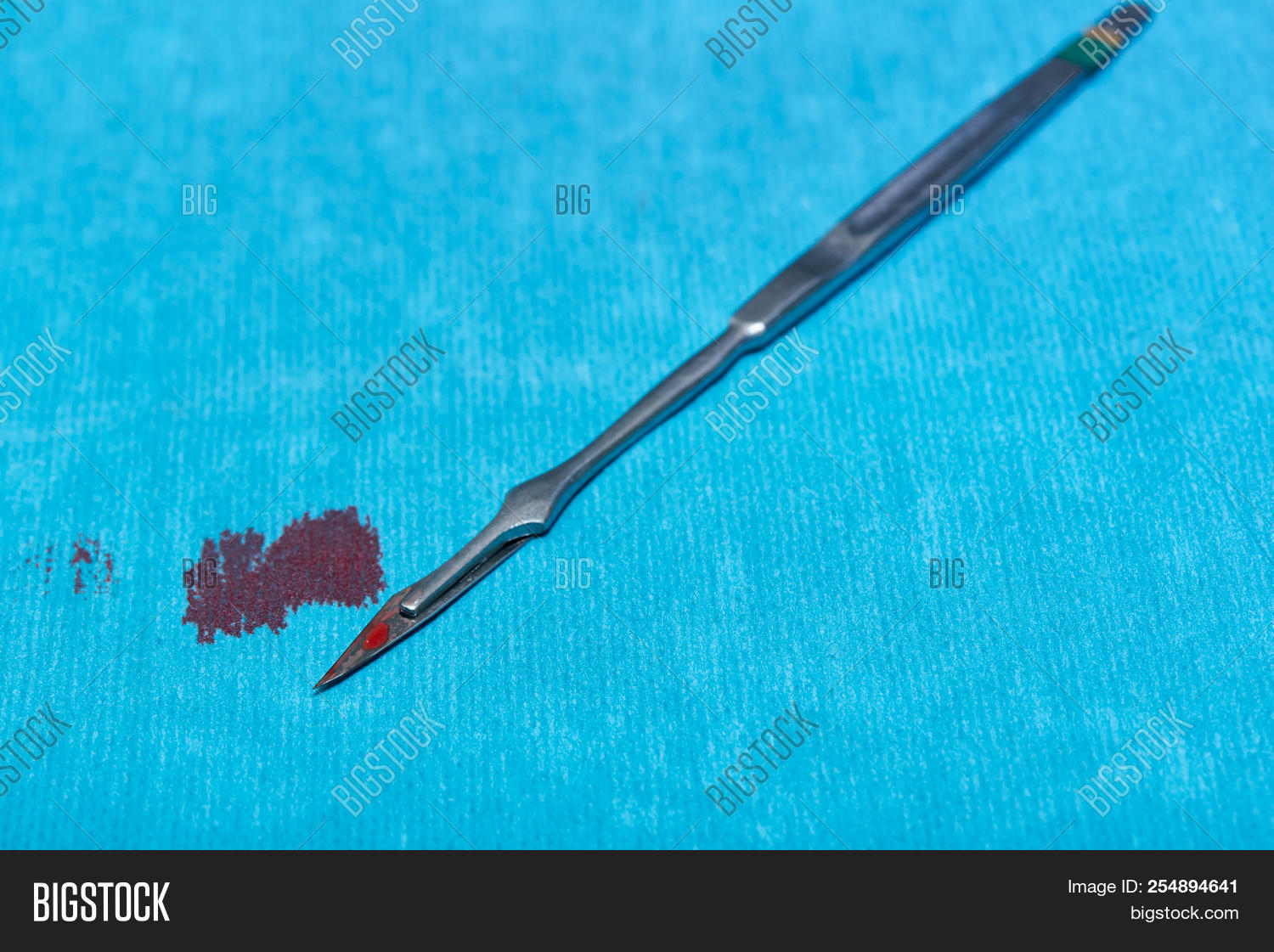 background,blade,blood,blue,care,concept,cut,danger,drape,equipment,hazard,health,healthcare,hospital,instrument,knife,medical,medicine,metal,metallic,object,operating,operation,professional,razor,room,scalpel,sharp,stained,stainless,steel,sterile,supplies,surgeon,surgery,surgical,table,tool,work
