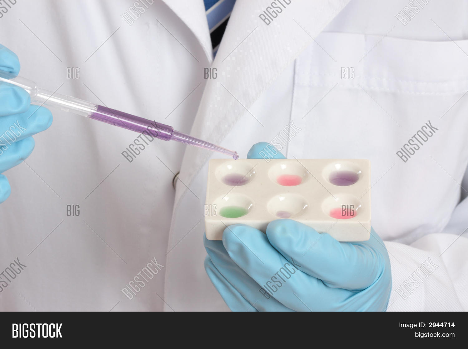 A medical forensic or laboratory scientist using a spot plate and