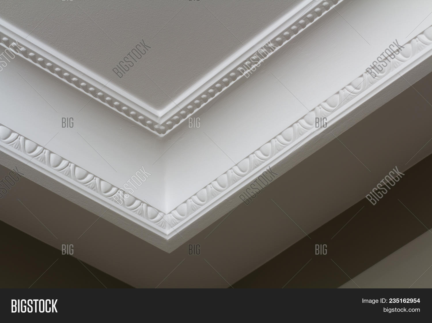 Ornamental White Molding Decor On Ceiling Of White Room Close