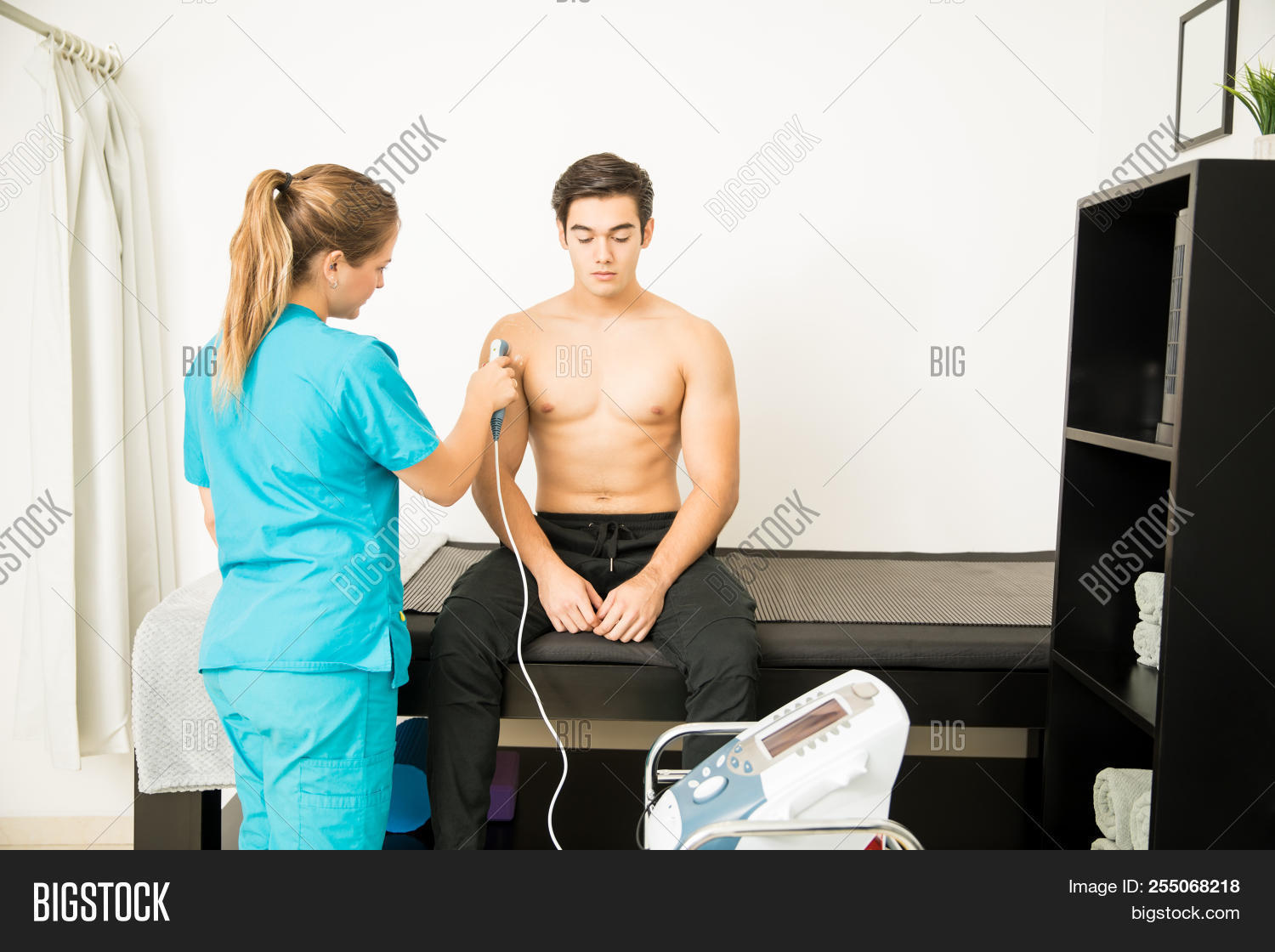 20s,Alternative,Athlete,Bed,Caucasian,Clinic,Cure,Customer,Device,Doctor,Electric,Electrical,Electrotherapy,Female,Health,Holding,Hospital,Indoors,Injury,Iontophoresis,Kinesiology,Male,Man,Massage,Medicine,Orthopedic,Pain,Patient,People,Physical,Physiotherapist,Physiotherapy,Probe,Receiving,Recovery,Rehabilitation,Relief,Shirtless,Shoulder,Sitting,Standing,Therapist,Therapy,Treatment,Two,Ultrasound,Wave,Woman,Young