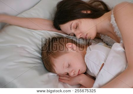 Mom And Son Sleeping Together. Mom Hugging Her Son. image & stock photo