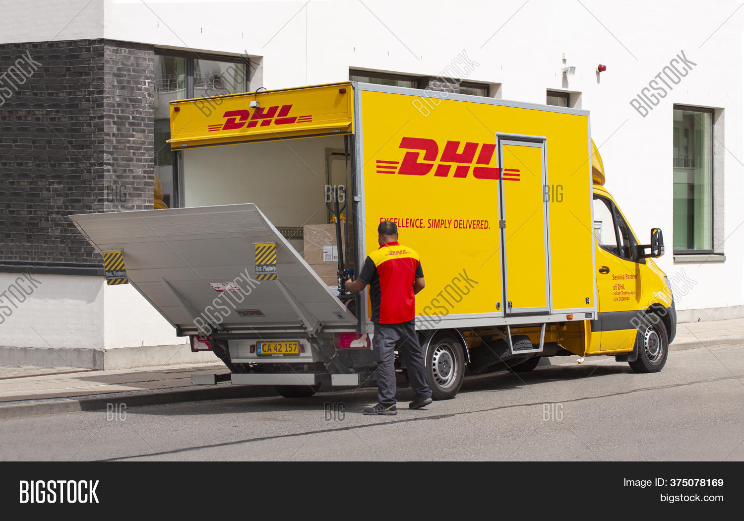 courier, 																					service, 																					activity, 																					auto, 																					box, 																					business, 																					cargo, 																					carry, 																					container, 																					delivery, 																					dhl, 																					equipment, 																					freight, 																					heavy, 																					hold, 																					industrial, 																					industry, 																					job, 																					lifting, 																					loader, 																					loading, 																					logistic, 																					lorry, 																					machine, 																					man, 																					men, 																					move, 																					occupation, 																					package, 																					packing, 																					parked, 																					people, 																					person, 																					professional, 																					shipment, 																					shipping, 																					speed, 																					standing, 																					storage, 																					track, 																					trading, 																					transport, 																					transportation, 																					truck, 																					trucking, 																					uniform, 																					vehicle, 																					work, 																					worker