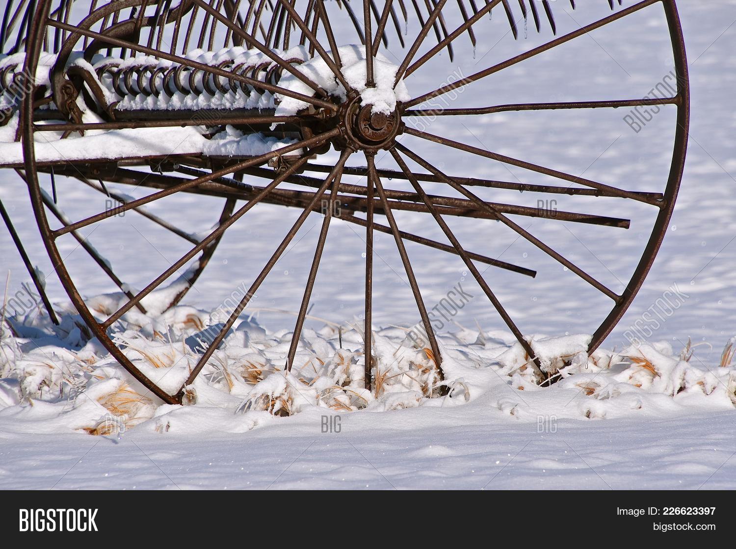 The Steel Wheel Of An Old Dump Rake Left In The Snow image & stock ...