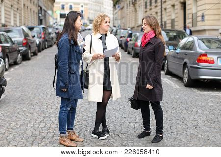 Chinese International Student Speaking With Teacher Outside In  . Concept Of Studying Abroad And Lea