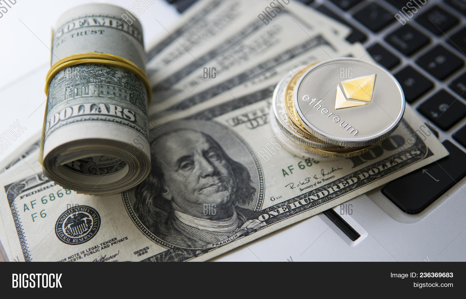 Ethereum Cryptocurrency On Top Of 100 Dollar Biils A Laptop Ethereum Cryptocurrency On Top Of 100