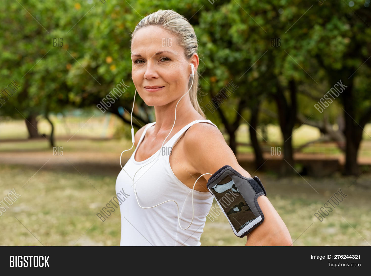 40s,active,armband,beautiful,blonde,blonde hair,break,earphones,exercise,fit,fitness,happy,health,healthy,jog,jogger,lifestyle,listening,listening to music,looking,looking at camera,mature,matured,mid adult woman,middle aged woman,mp3,music,outdoor,park,people,person,proud,rest,resting,routine,run,runner,satisfied,senior,smile,sport,sporty,sporty woman,training,wellbeing,wellness,woman,workout