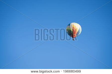 Hot air balloon flies in clear blue sky - Stock Image - Everypixel