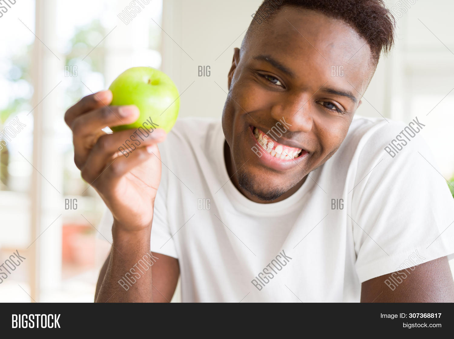adult,african,afro,american,apple,background,bite,bitting,black,care,casual,cheerful,close up,confident,dental,dentist,diet,eat,food,fresh,fruit,green,hand,happiness,happy,health,health care,healthy,holding,home,indoors,lifestyle,man,nutrition,organic,person,portrait,smile,t-shirt,teeth,vegetarian,white,young