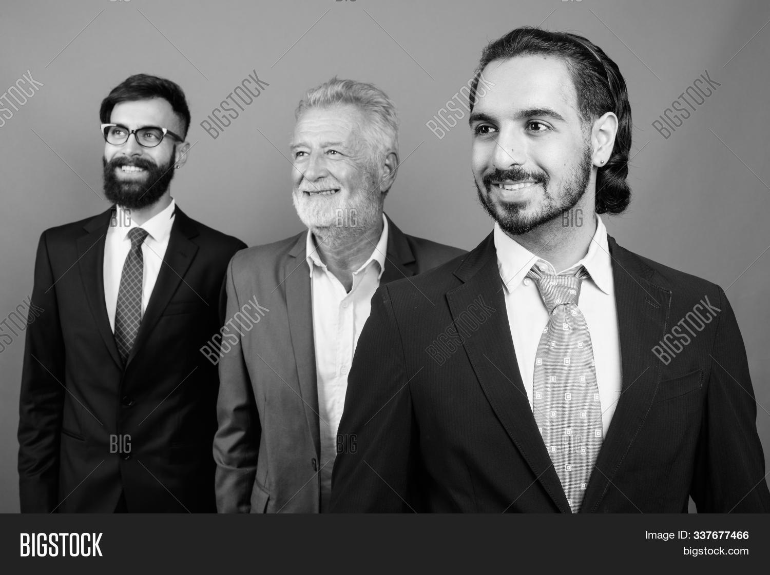 adult, 																					background, 																					beard, 																					businessman, 																					eastern, 																					eyeglasses, 																					friendship, 																					group, 																					handsome, 																					happy, 																					hipster, 																					indian, 																					male, 																					men, 																					middle, 																					monochrome, 																					multi-ethnic, 																					mustache, 																					nerd, 																					old, 																					partnership, 																					people, 																					persian, 																					person, 																					portrait, 																					senior, 																					shot, 																					smiling, 																					studio, 																					suit, 																					teamwork, 																					thinking, 																					three, 																					together, 																					young