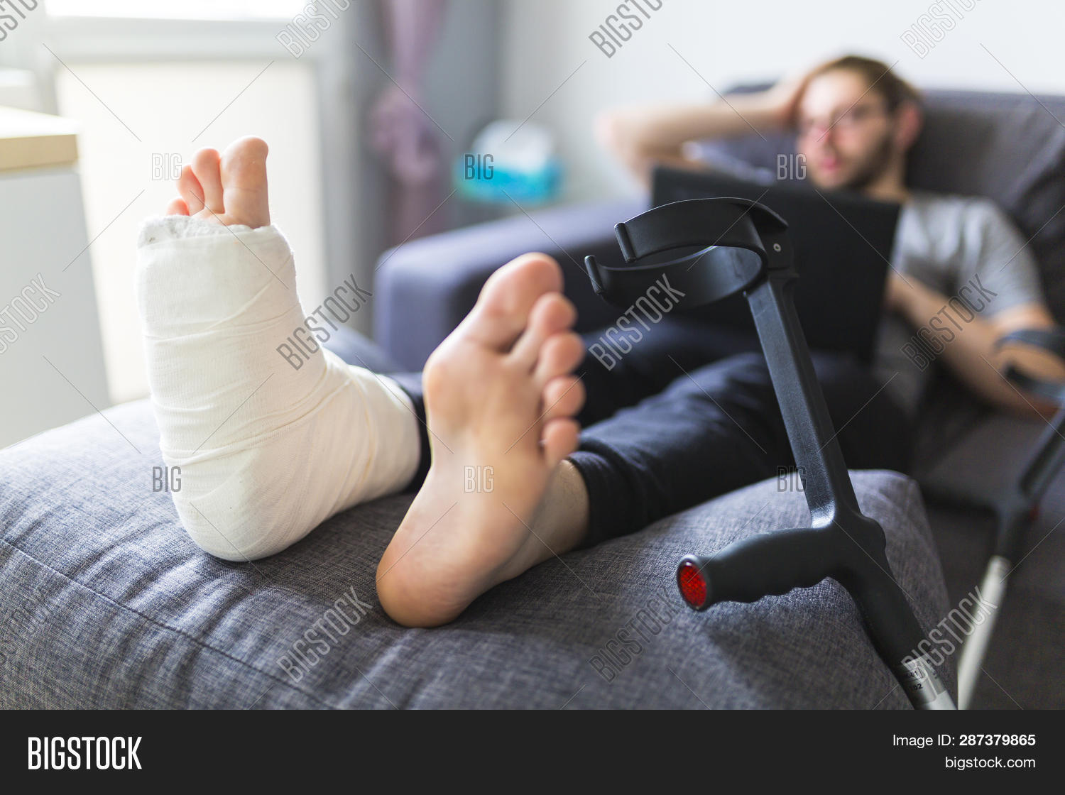 accident,anatomy,bandage,bone,broken,care,crutches,disabled,foot,fracture,health,healthcare,home,human,hurt,illness,injured,injury,insurance,joint,leg,male,man,medicine,orthopedic,pain,patient,person,plaster,recovery,rehabilitation,sofa,treatment,young
