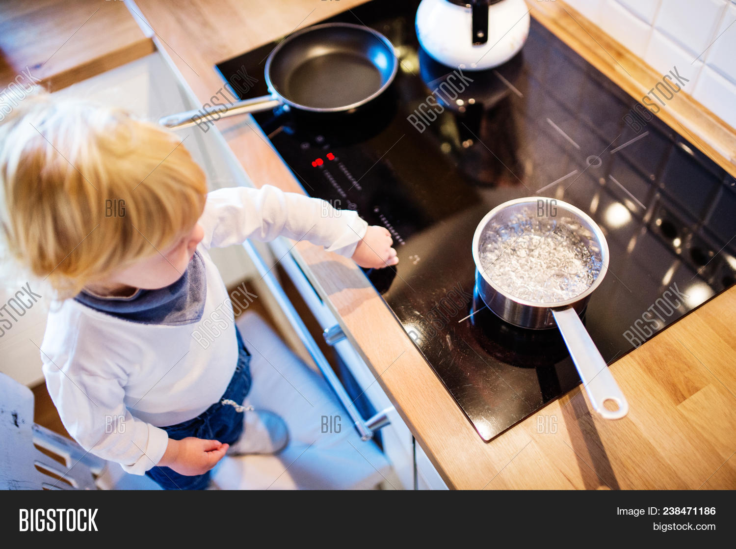 above,accident,alone,baby,blond,boiling,boy,caucasian,ceramic,chair,child,childhood,concept,curious,cute,dangerous,domestic,exposed,flat,gorgeous,hob,home,hot,house,indoors,injury,inside,interior,kid,kitchen,little,male,open,person,pot,reach,reaching,risk,risky,safety,scald,security,situation,small,standing,stove,toddler,top,view,water