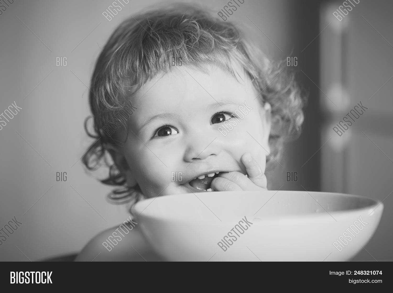 Child Eats Porridge Portrait Of Sweet Little Laughing Baby Boy
