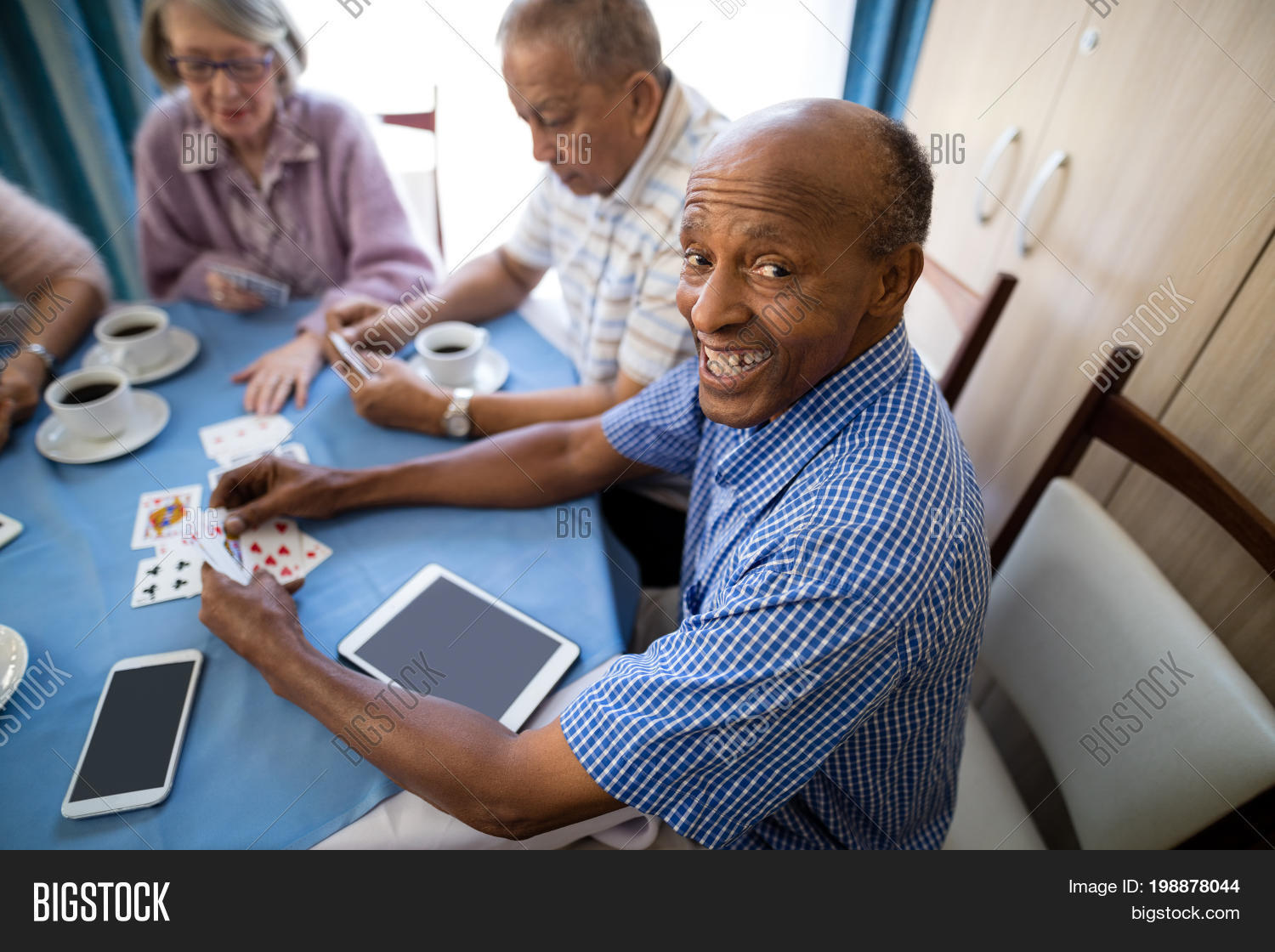 60s,65-69 years,70s,active,active seniors,african ethnicity,assisted living,beverage,black,cards,casual clothing,caucasian,caucasian ethnicity,coffee,communication,competition,cup,digital tablet,drinking,elderly,enjoyment,female,friendship,geriatrics,golden years,happy,healthcare and medicine,holding,lifestyle,male,man,mixed-race,mixed-race person,mobile phone,multi-ethnic,nursing home,playing,refreshment,relaxation,retirement,retirement community,senior,senior men,senior women,sitting,smiling,strategy,technology,togetherness,woman