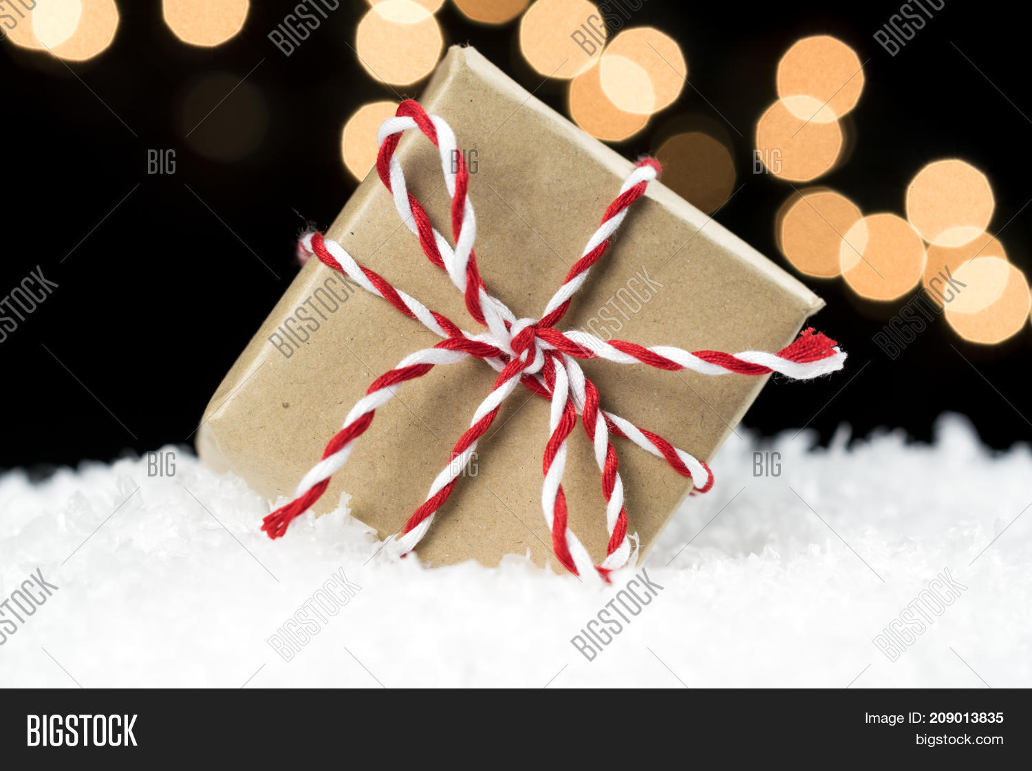 Small Gift Box Wrapped In Brown Paper And Twine Wedged In White
