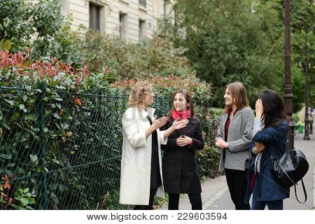 Chinese International Student Speaking With Teacher Outside In  . Concept Of Studying Abroad And Lea