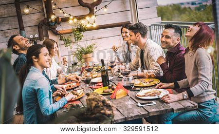 Young People Dining And Having Fun Drinking Red Wine Together On Balcony Rooftop Dinner Party - Happ