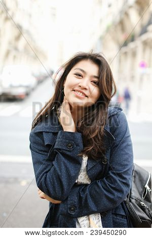 Chinese Cute Female Tourist Standing In Road Background In Europe. Concept Of Tourism And Internatio