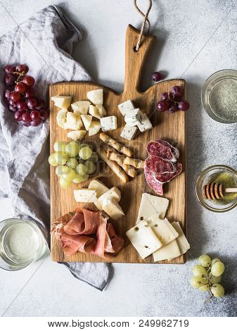 Cheese And Meat Wine Snack Set On Wood Board . Variety Of Cheese, Salami, Prosciutto, Bread Sticks,