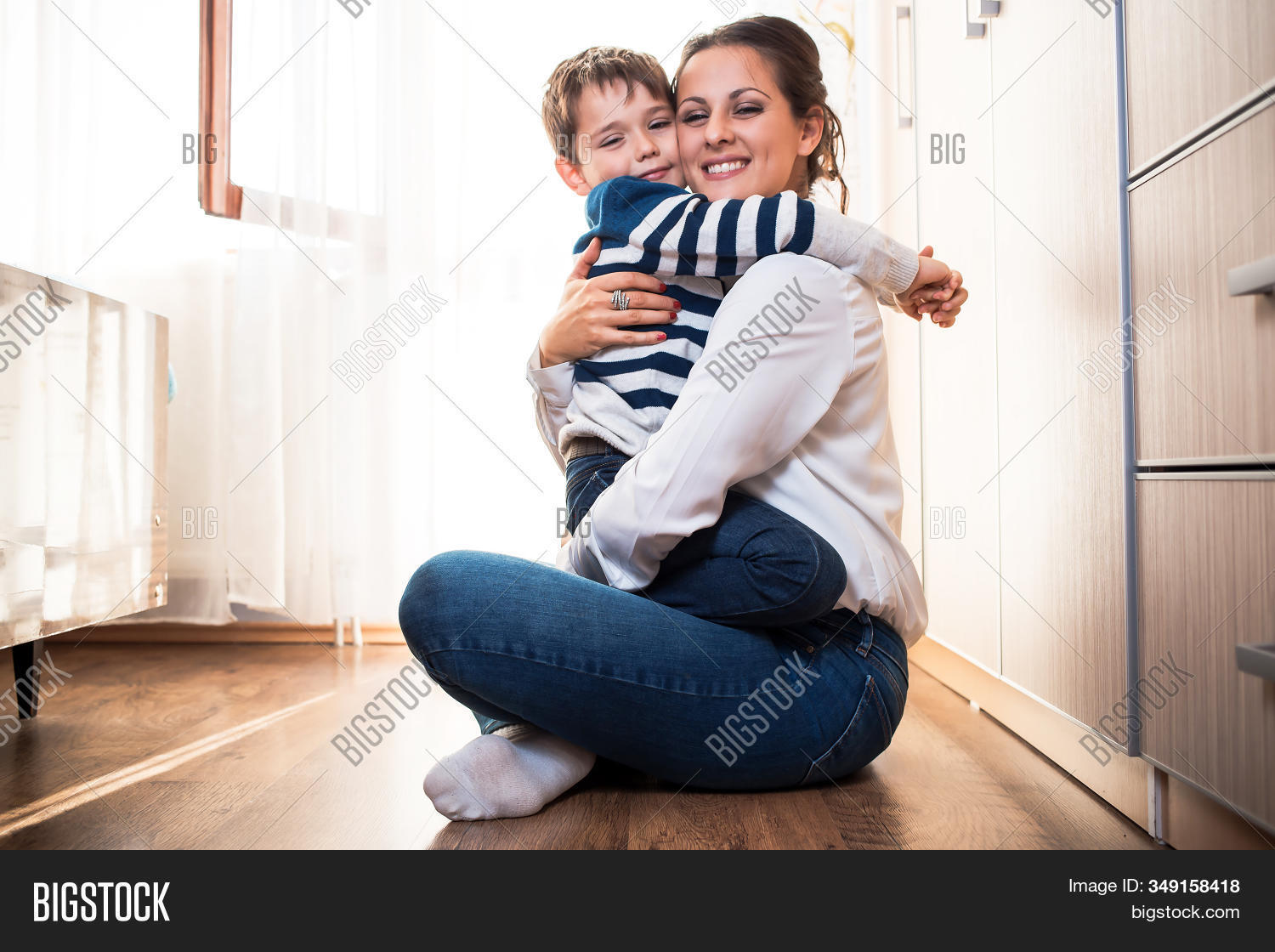 care,smiling,indoors,playing,lap,sitting,tenderness,relationship,adorable,affectionate,affection,hug,kiss,smile,motherhood,parenthood,holding,joyful,parenting,blue,white,cheerful,adult,leisure,home,beautiful,lifestyle,together,cute,portrait,two,fun,little,happy,parent,female,happiness,caucasian,people,young,childhood,boy,mom,woman,child,family,son,mother,kid