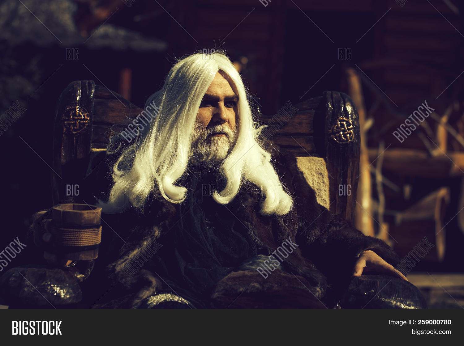 Druid Old Man With Long Silver Hair Beard In Fur Coat Sits In